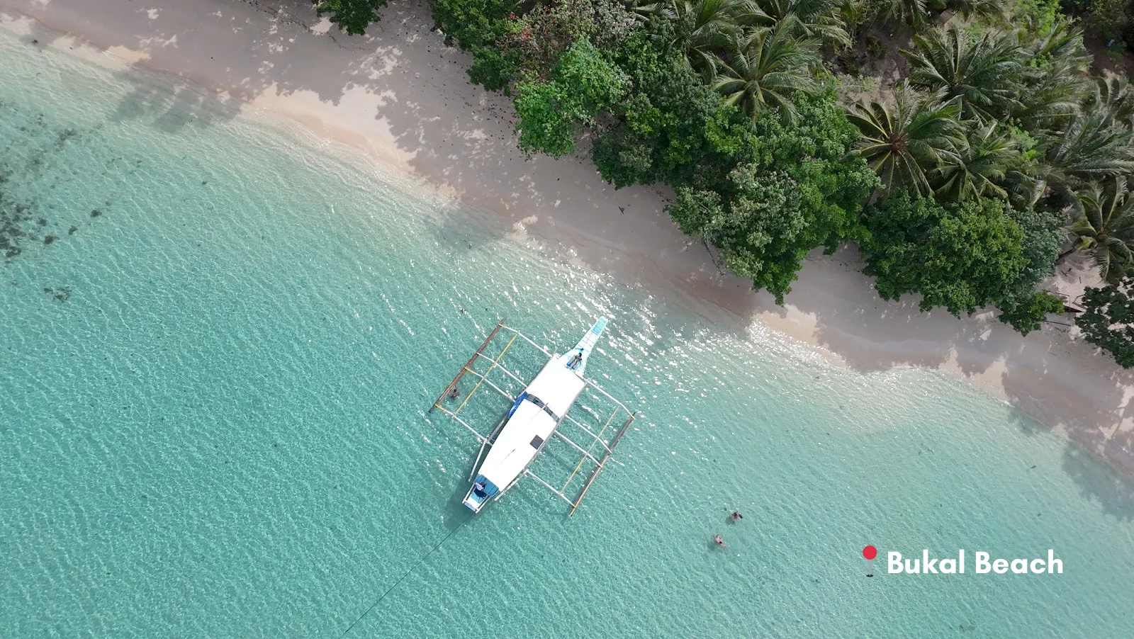 Aerial view of Bukal Beach, a virgin and secluded beach with crystal clear turquoise waters in Malampaya Sound, Palawan.
