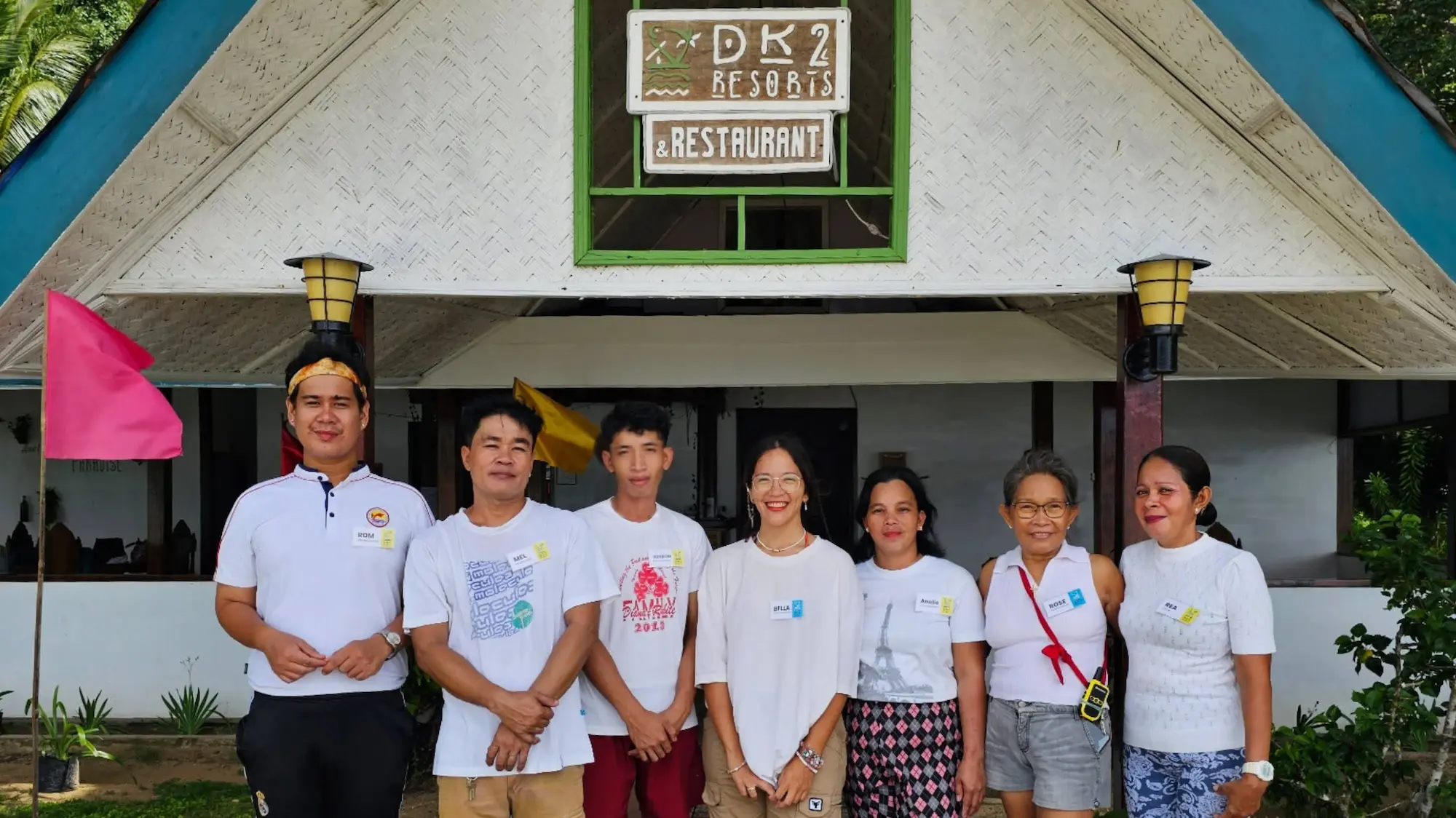 DK2 Resort family and team members smiling in front of the restaurant entrance in El Nido, Palawan.