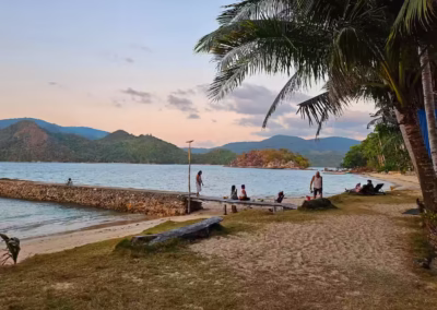 Sunset panoramic view of the private beachfront at DK2 Family Resort. Stone pier and safe swimming area free from crowds.